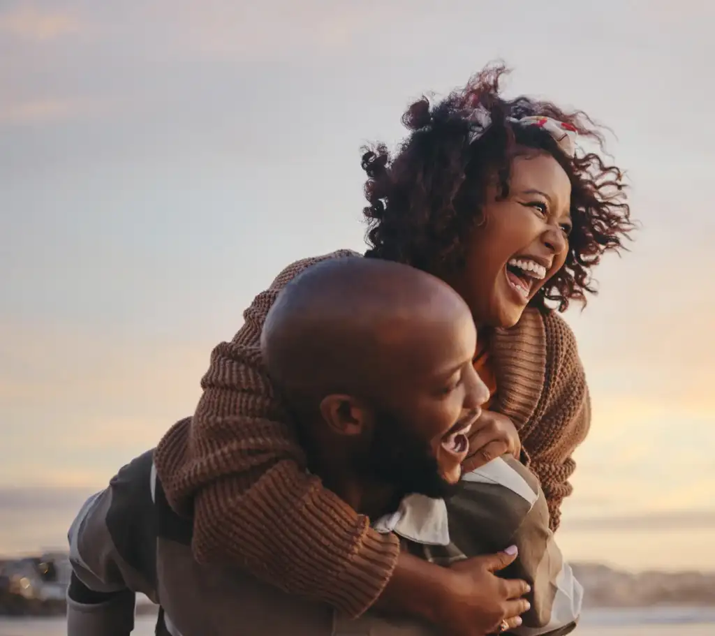 Couple laughing together outdoors at sunset, expressing joy, connection, and living with purpose